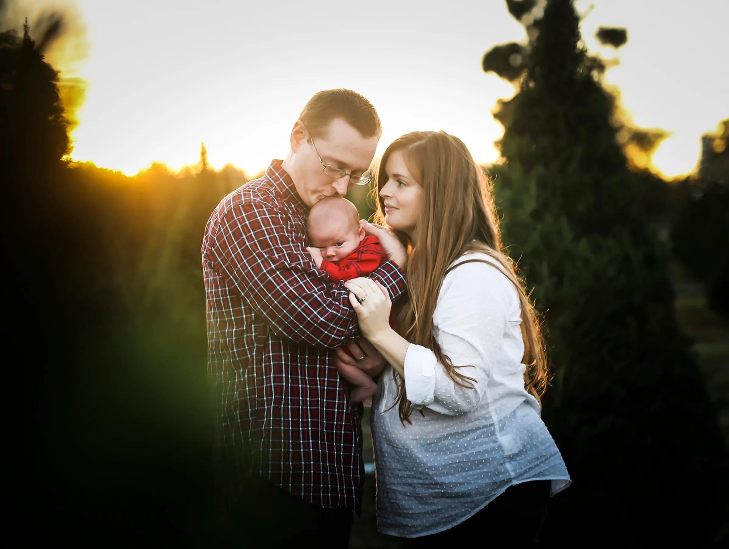 A family embracing in a field at sunset